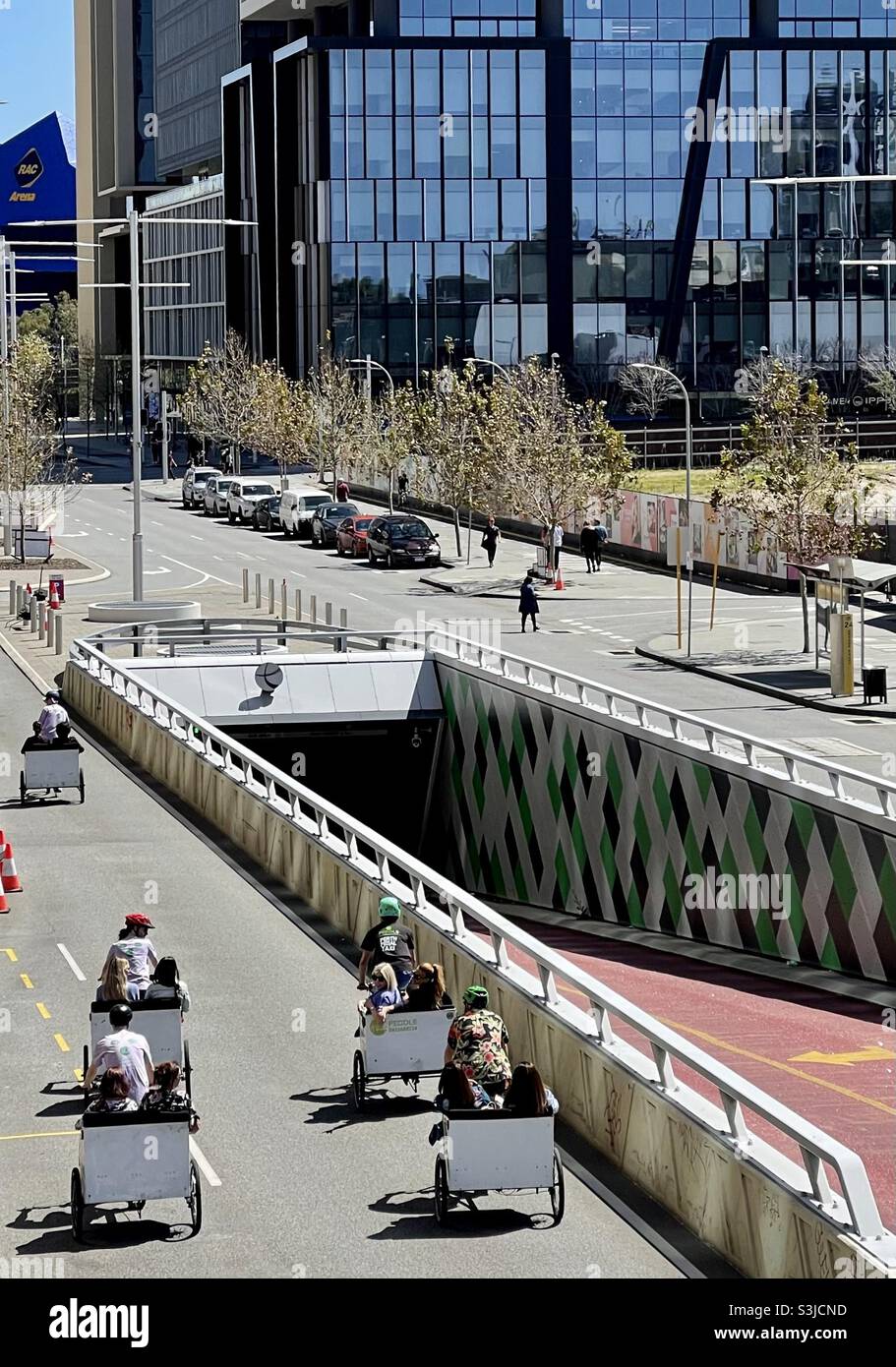 Touristen, die CBD von Perth auf Dreirädern erkunden Stockfoto