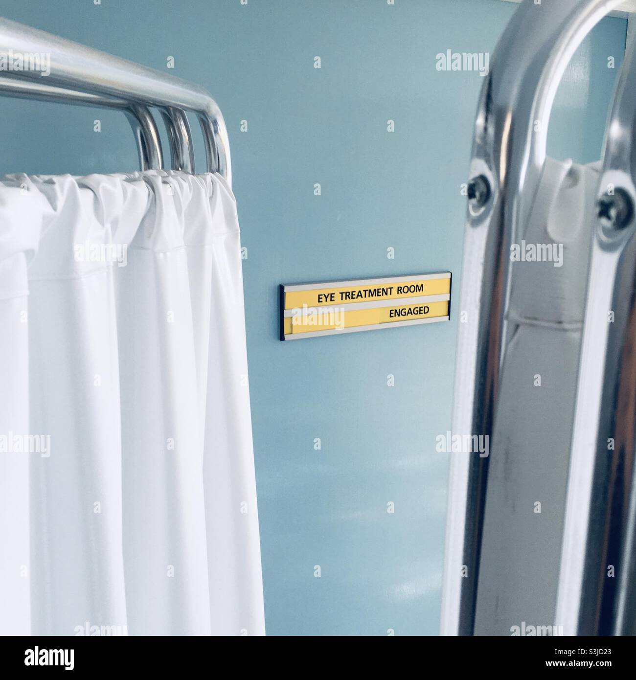 Augenbehandlungsraum eingeschaltet - Blauaugen-Kliniktür und Bildschirme Detail - medizinische Station Stockfoto