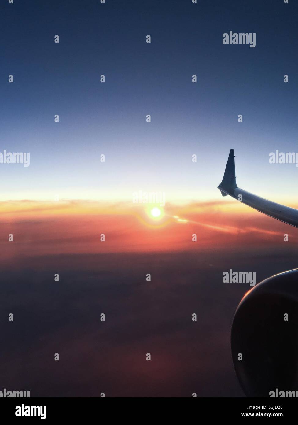 Sonnenuntergang von einem Flugzeug mit Flügelspitze und einem Teil des Motors. Stockfoto