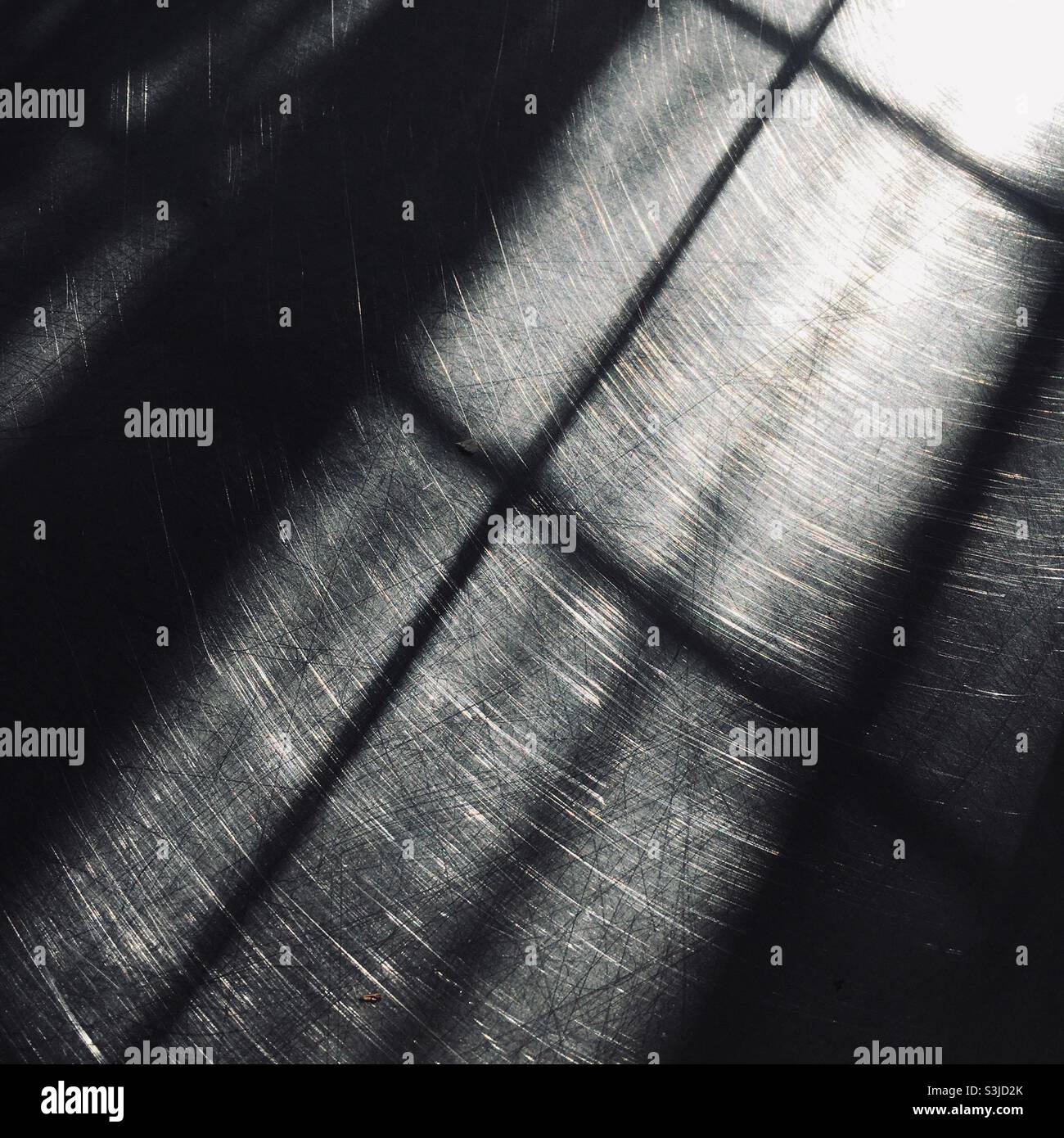 Licht- und Schattenreflexionen auf einer metallisch-verchromten Oberfläche Stockfoto