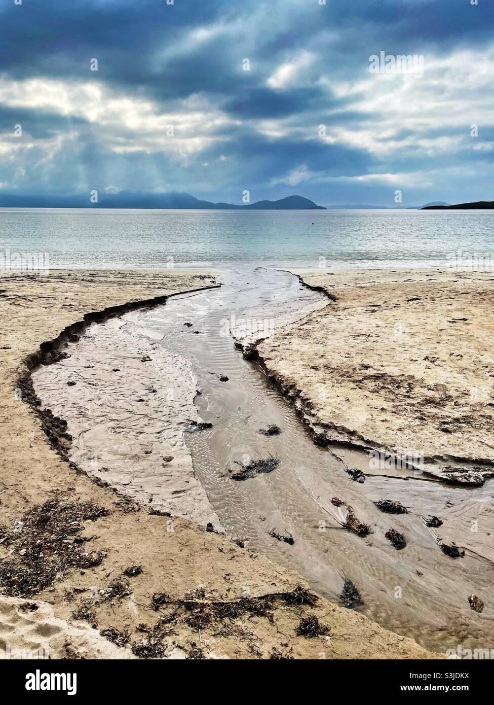 Bach, der ins Meer eindringt, Ballinskelligs Beach, Ballinskelligs Bay, County Kerry, Irland, August. Stockfoto