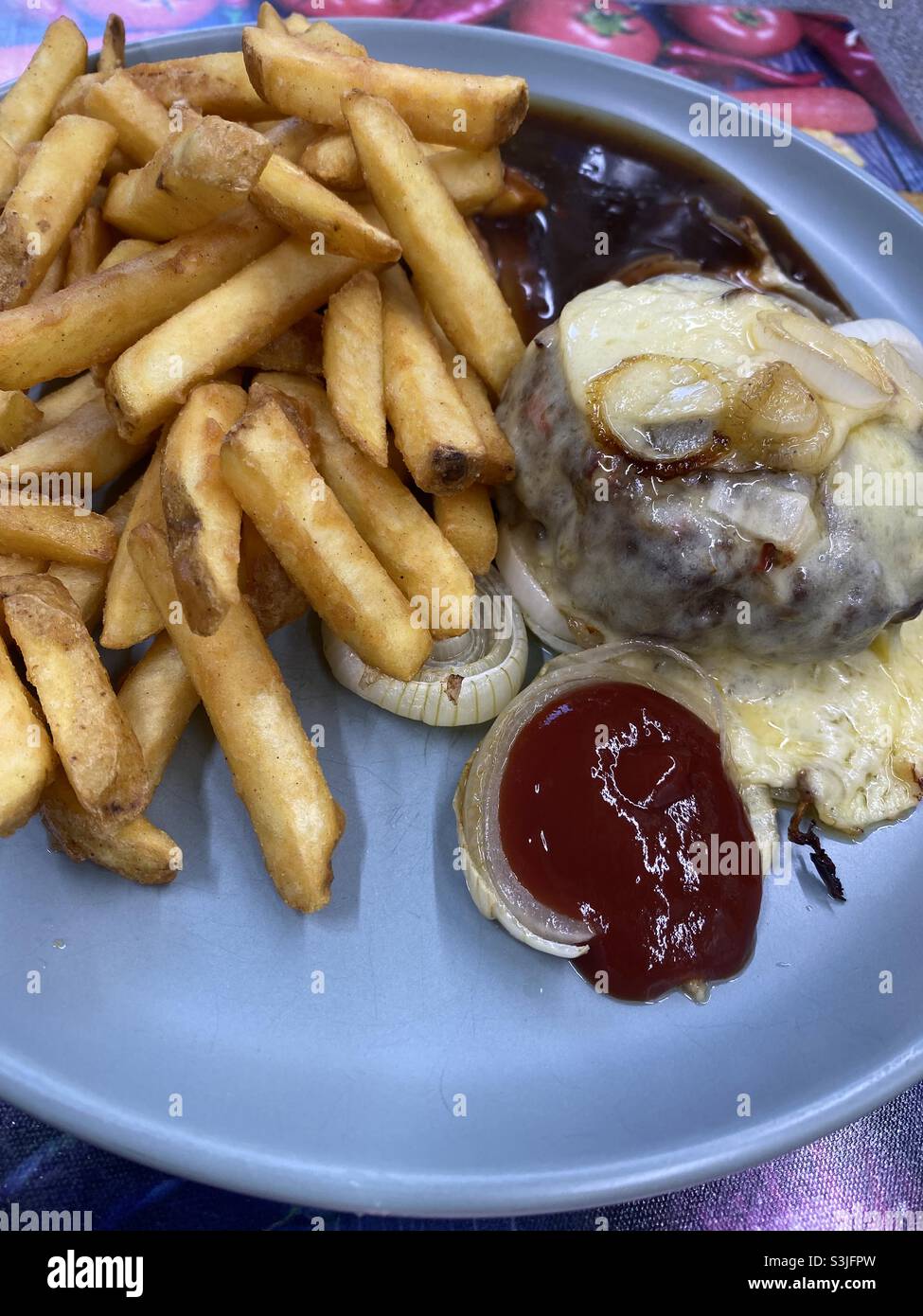 Käse Burger und Haut auf Pommes und Zwiebeln mit BBQ-Sauce - Smartphone-aufgenommenes Stockfoto
