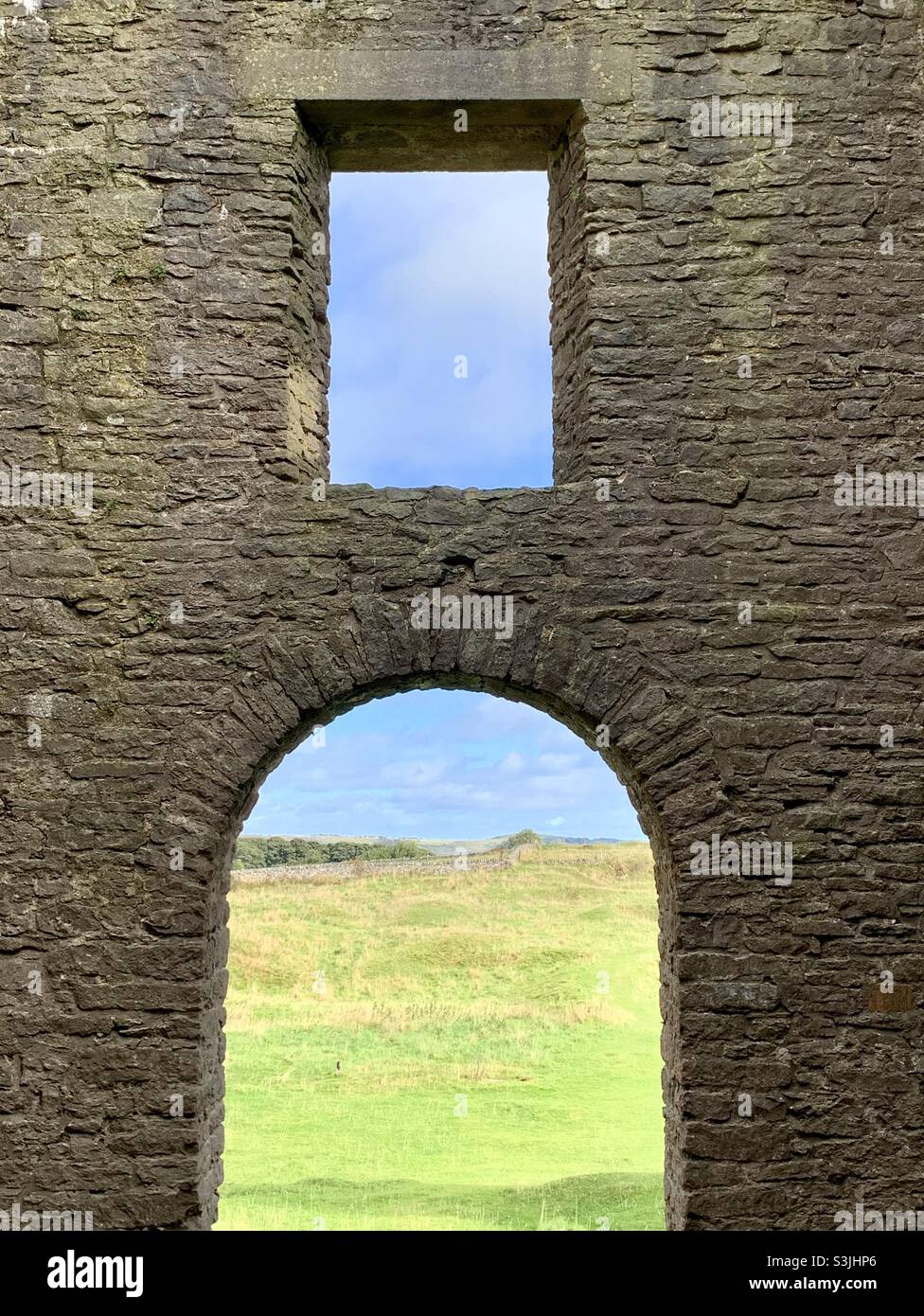 Blick auf die grüne Landschaft durch Steinbogenfenster Stockfoto