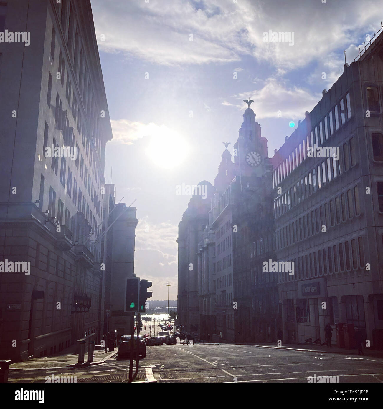 Blick die Straße hinunter auf das Lebergebäude mit der Sonne im Hintergrund. Liverpool Stockfoto