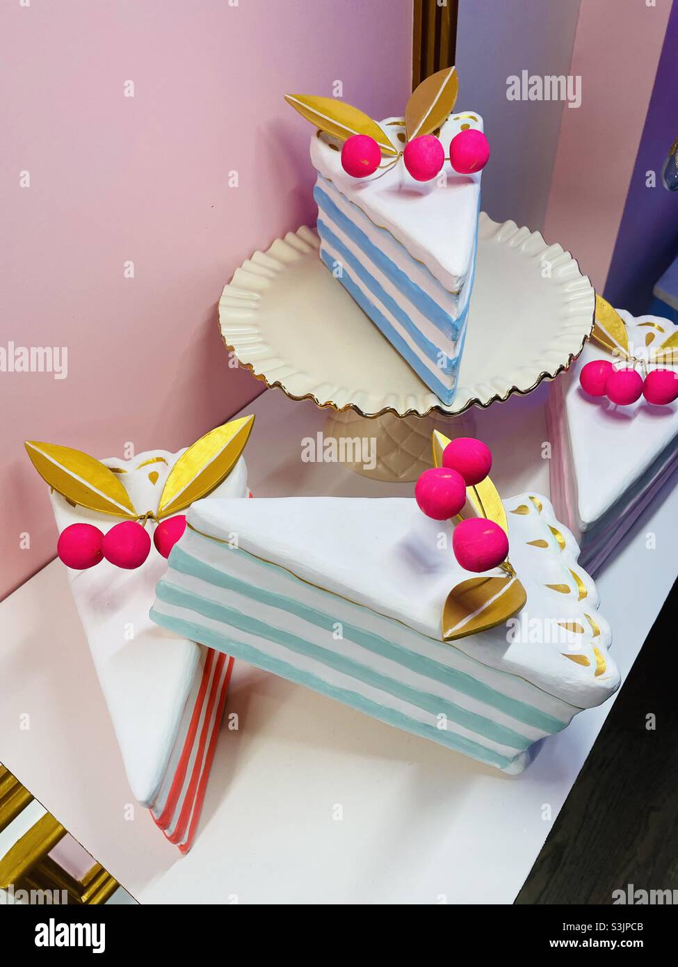 In-Store-Präsentation von bunten und fantasievollen Kuchenscheiben als Kunst - Smartphone-aufgenommenes Stockfoto