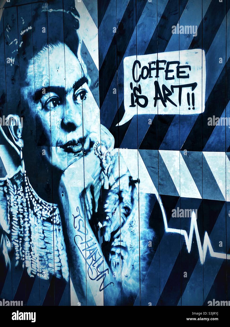 Graffiti-Gemälde auf einer Holzwand, die Werbung dafür machen, dass Kaffee Kunst ist Stockfoto