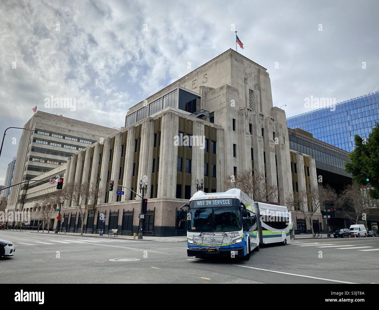 LOS ANGELES, CA, 2021. JANUAR: Der außer Betrieb fahrende Bus fährt vor dem Gebäude der Los Angeles Times im Stadtzentrum ab - Smartphone-aufgenommenes Stockfoto