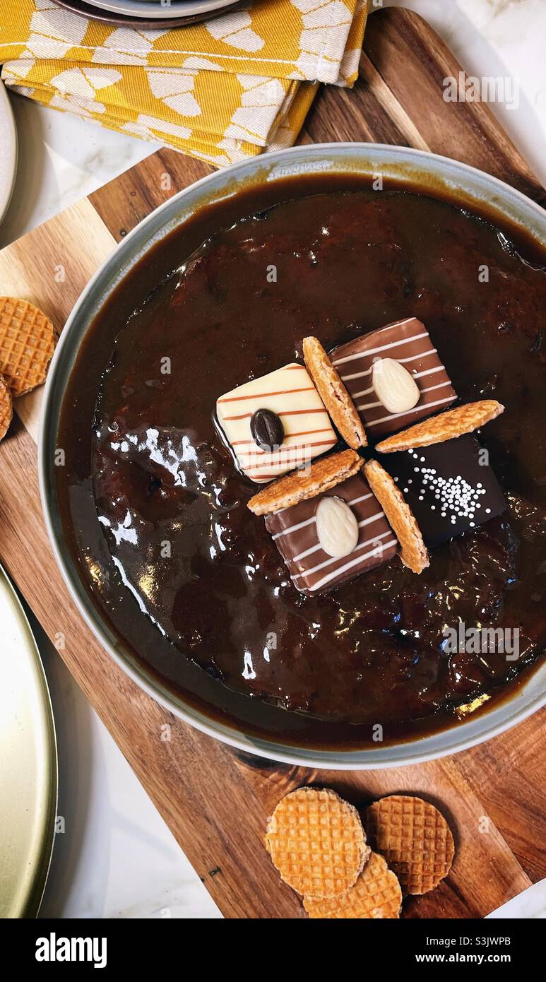 Schokoladen-Tropf-Kuchen mit Pralinen darauf Stockfoto