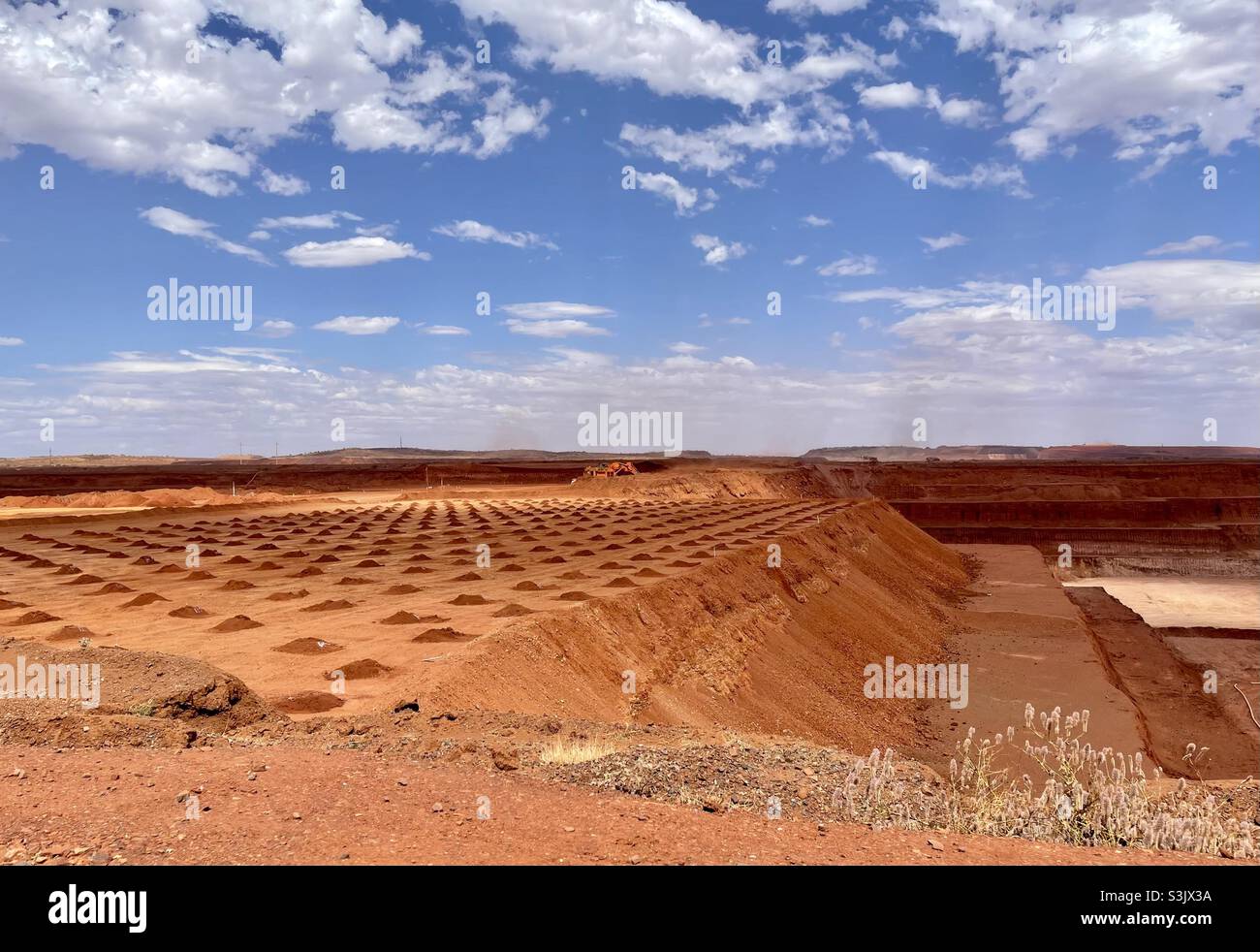 Bohrlöcher, die bereit sind, mit Sprengstoff gefüllt zu werden, werden an einem Eisenerzminenstandort in Pilbara, Westaustralien, gebohrt Stockfoto