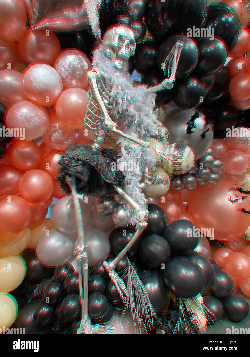 Halloween-Display zeigt mehrfarbige Ballons und ein großes Kunststoff-Skelett, New York City, USA, 2021 - Smartphone-aufgenommenes Stockfoto