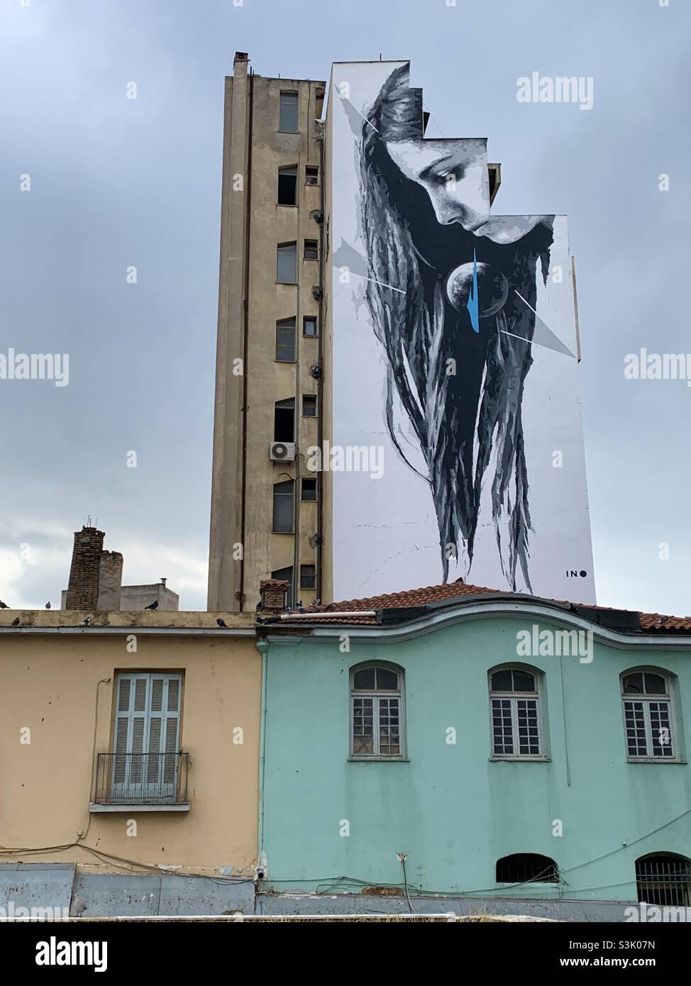 Graffiti-Wandbild eines Frauengesichts auf einem Wohnblock in Athen - Smartphone-aufgenommenes Stockfoto
