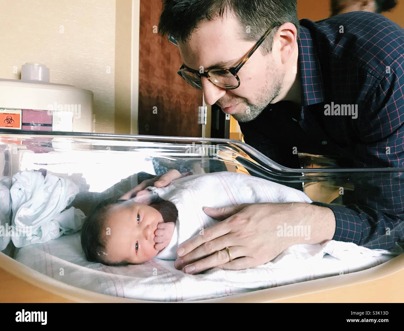 Ein Vater, der sein neugeborenes Kind in einem Krankenhaus in New Jersey, USA, ansieht. Stockfoto
