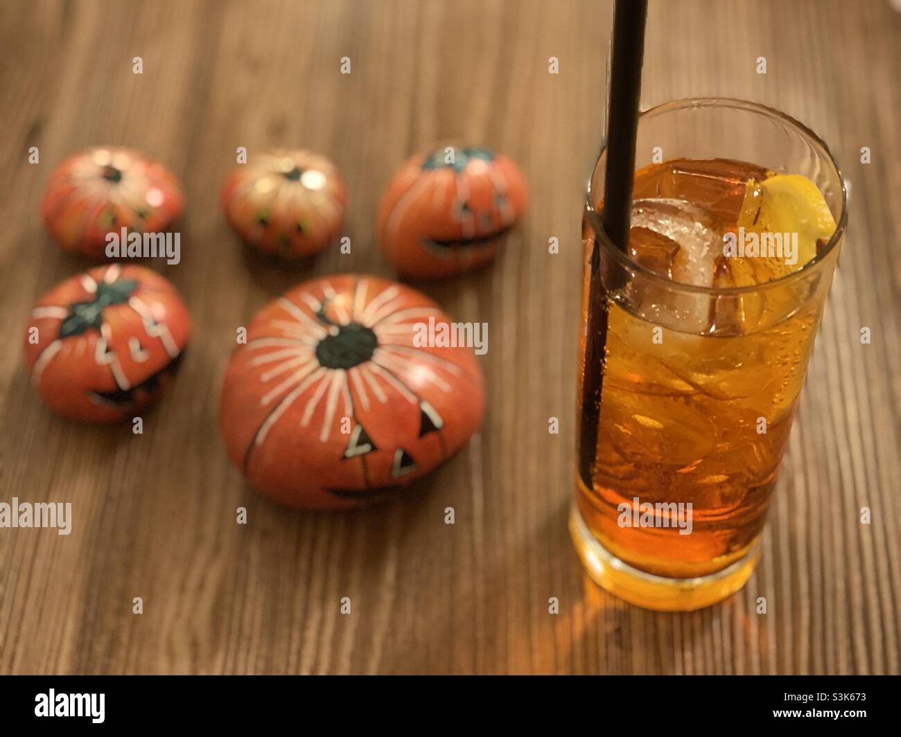 Feiern Sie Halloween mit einem orangefarbenen Getränk und steinernen Kürbissen Stockfoto