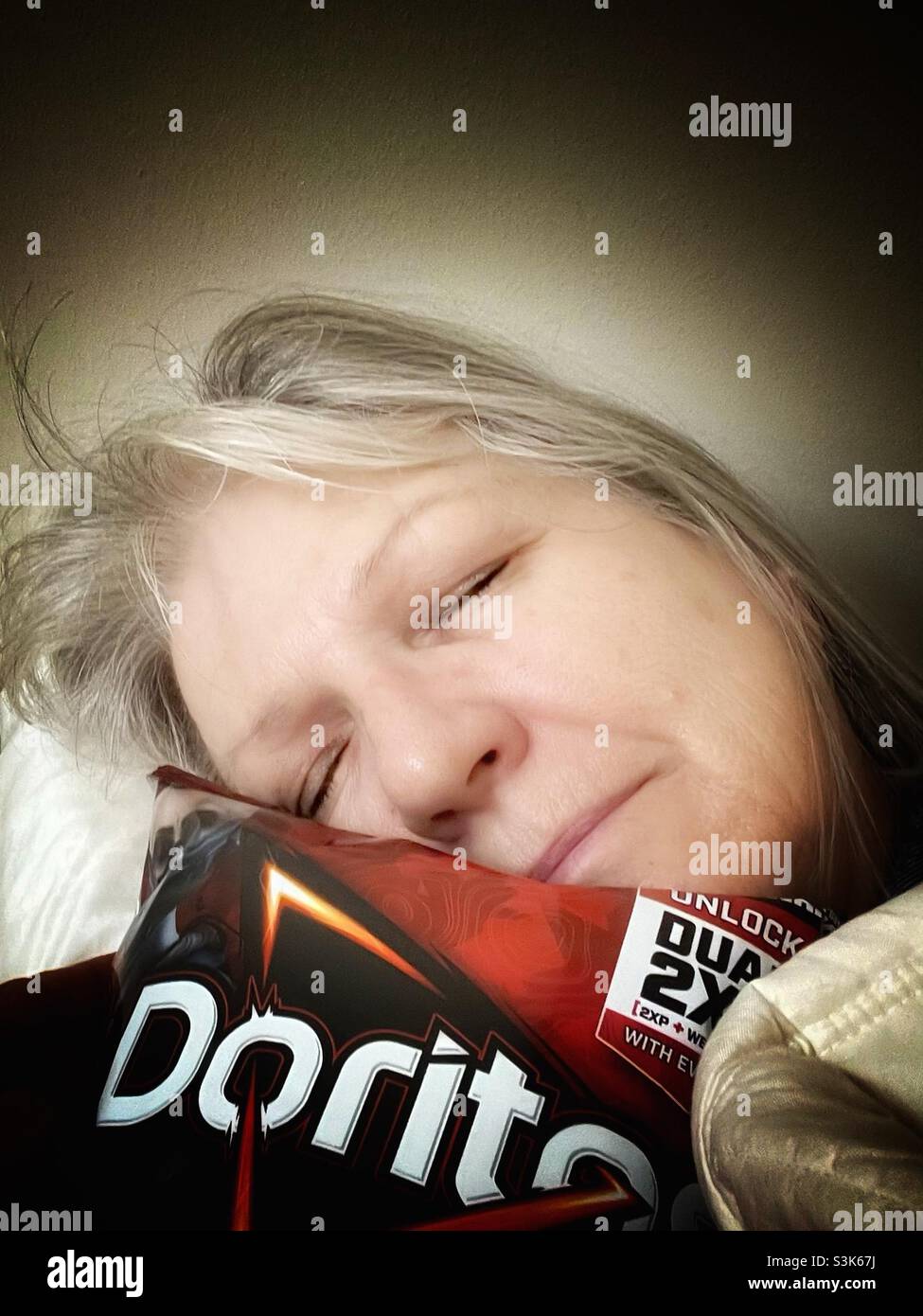 Schlafende Frau mit Doritos Stockfoto