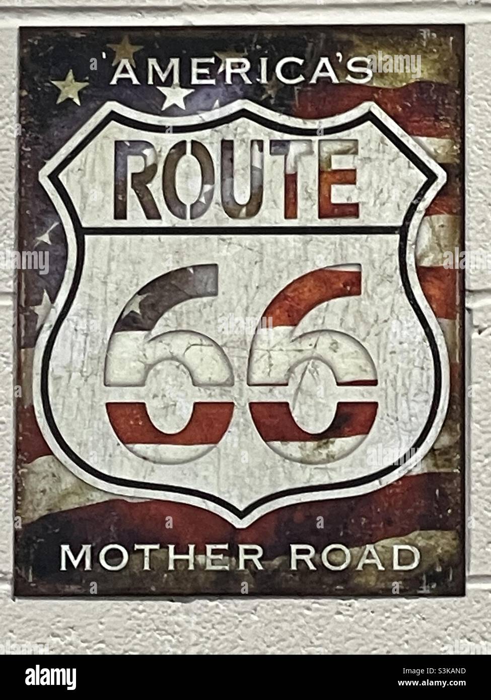 Ein Plakat an der Wand einer Autowerkstatt, das die berühmte amerikanische Straße Route 66, Amerikas Mutter Straße, zeigt. Stockfoto