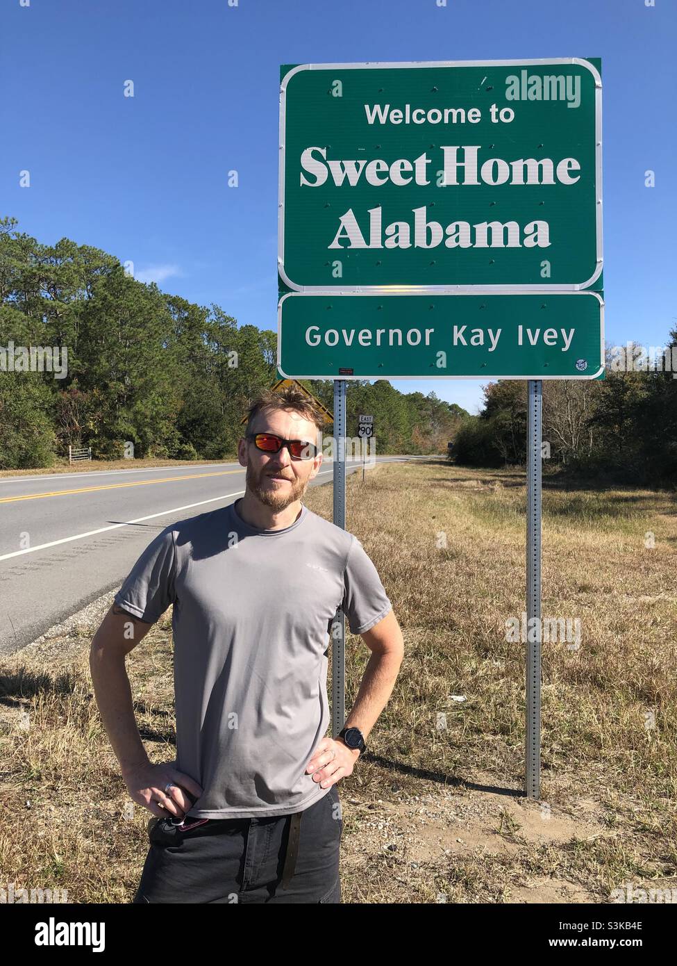 Ein Mann steht neben dem Schild der Alabama State Line Stockfoto