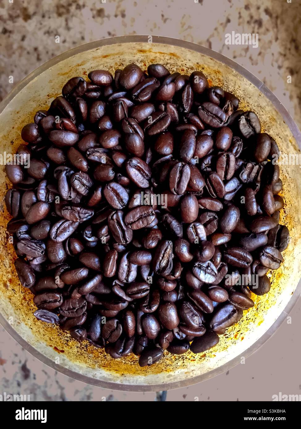 Arabica-Kaffeebohnen in Premiumqualität, nach Wert zweitgrößter weltweit gehandelter Rohstoff. Espresso-Röstung. Strahlend. Dunkel. Granittheke. - Smartphone-aufgenommenes Stockfoto
