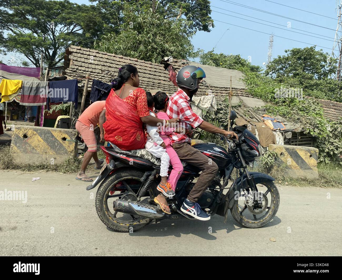 Eine Familie, die mit zwei Rädern unsicher auf der Straße unterwegs ist Stockfoto