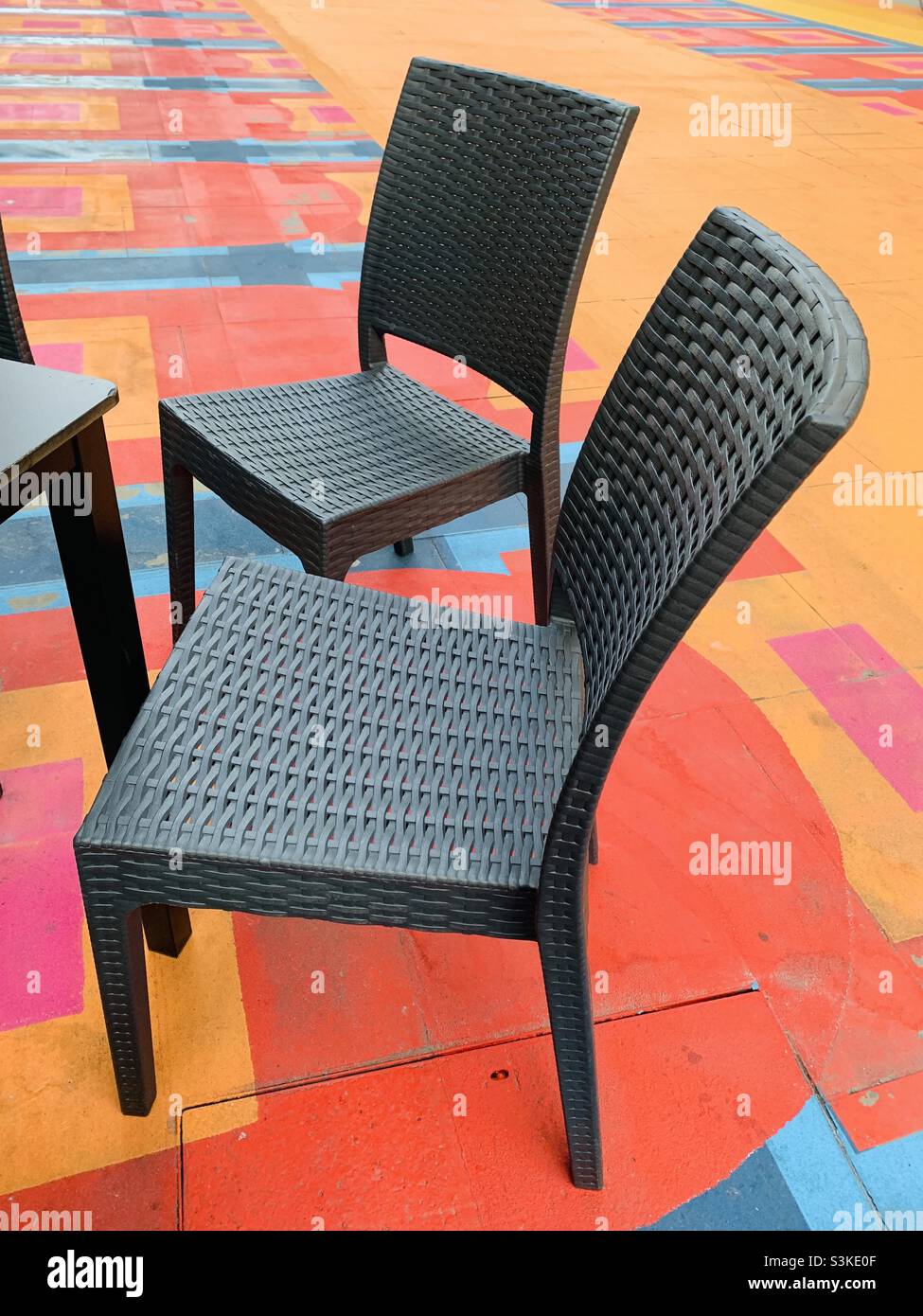 Schwarze Stühle vor farbenfrohem Hintergrund Stockfoto
