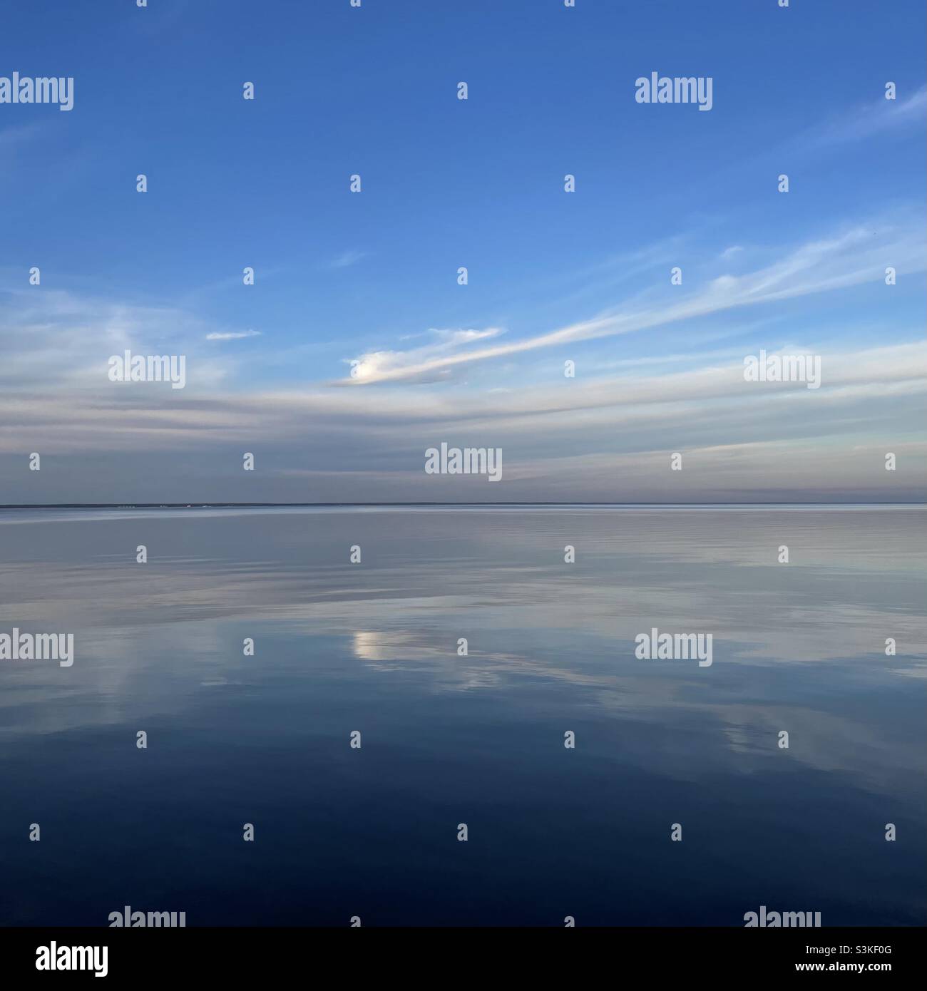 Sonnenuntergangswolken spiegeln sich auf dem ruhigen Bay Water Stockfoto