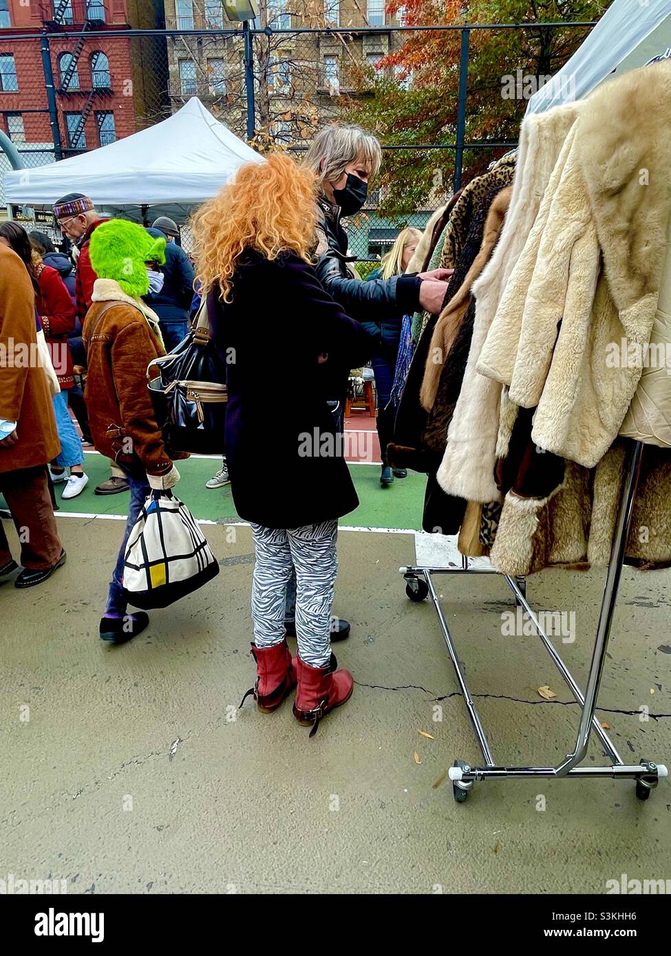 Orangefarbene Haare, grüner flauschiger Hut im Grand Bizarre in New York City Stockfoto