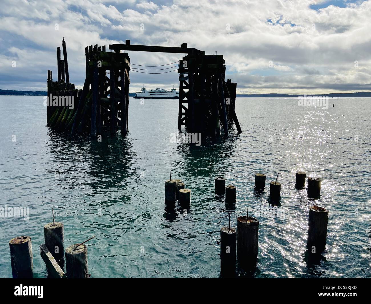 In Port Townsend fährt eine Washington State Ferry an den alten Docks in der Nähe der Innenstadt vorbei, auf dem Weg aus der Stadt, an einem brausenden Novembernachmittag. Stockfoto