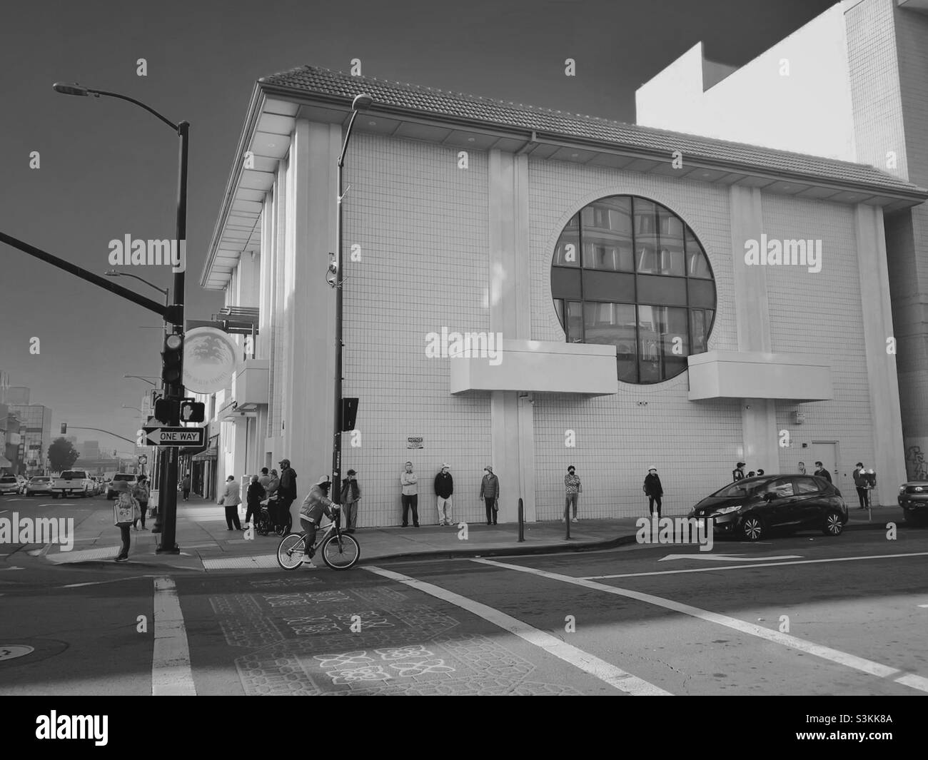 Die Menschen, die vom Gebäude der asiatischen Gesundheitsdienste unter dem frühen Morgenlicht in Chinatown, Oakland, Kalifornien, USA, gesäumt wurden Stockfoto