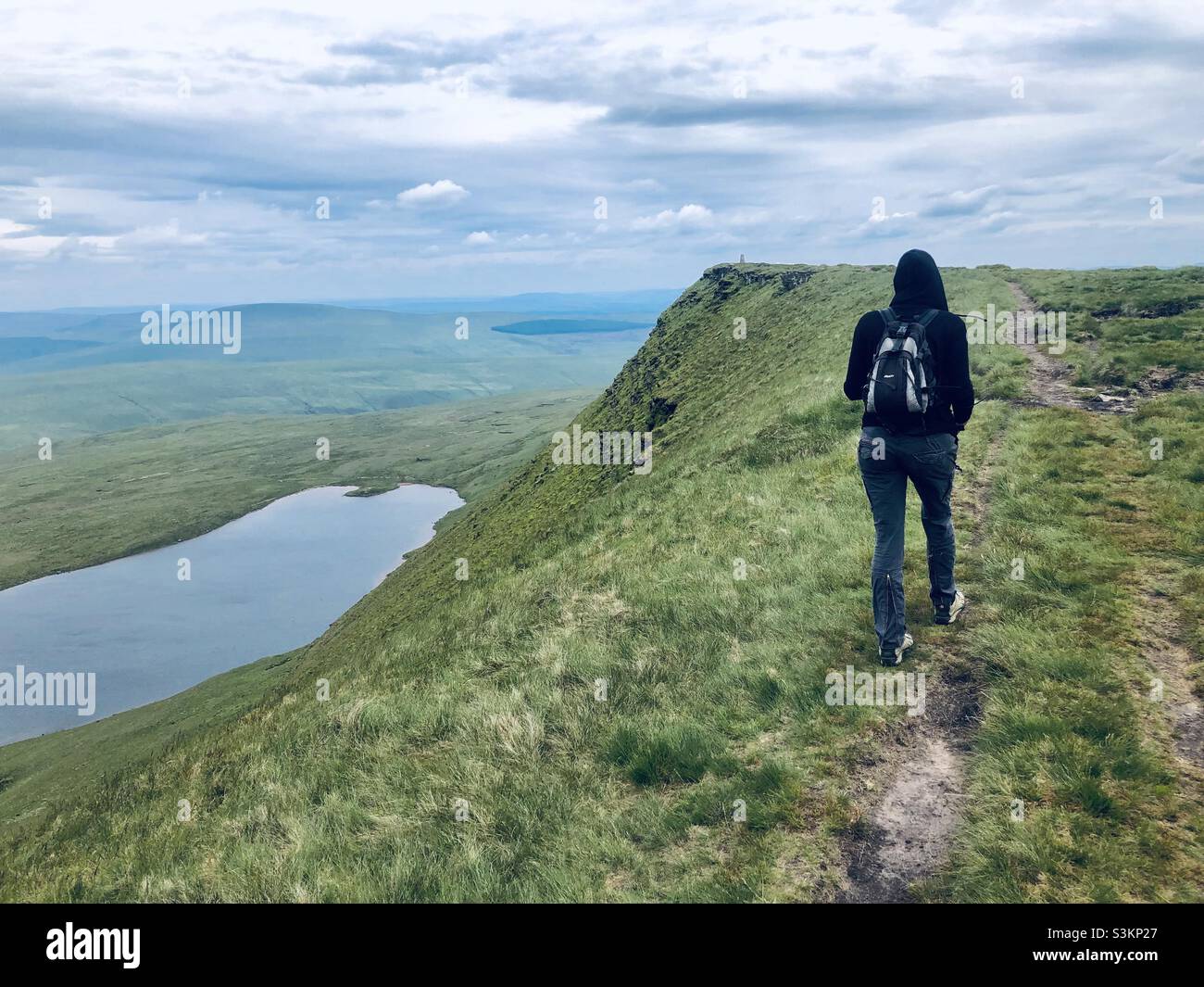 Eine Frau geht auf einem Bergweg in den Brecon Beacons - Smartphone-aufgenommenes Stockfoto