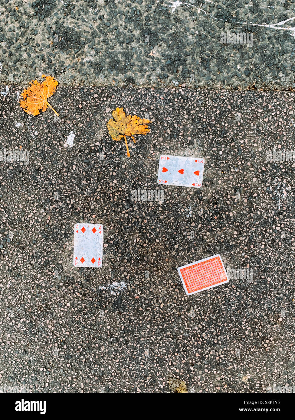 Spielkarten auf dem Bürgersteig gelassen Stockfoto