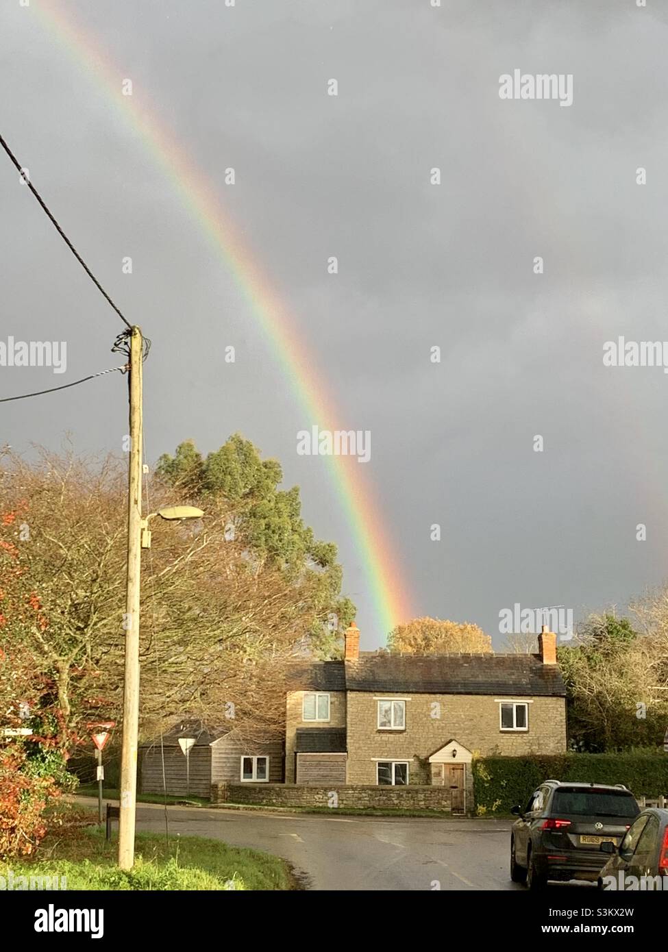 1st. Dezember, Fritwell, Oxfordshire, Großbritannien. WETTER: Ein Regenbogen erhellt den Himmel über Fritwell bei einem schnellen Regenschauer Stockfoto