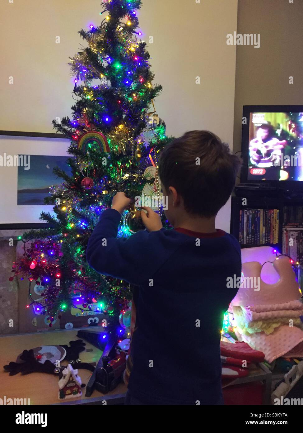 Junge, einen Weihnachtsbaum zu verzieren Stockfoto