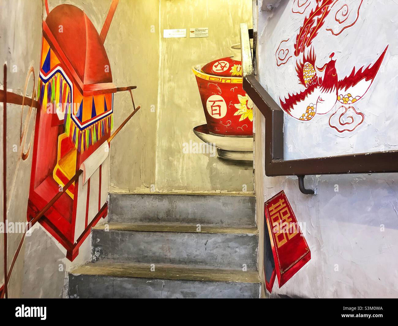 Wandgemälde an den Wänden des Treppenaufgangs zu einem Teeladen in einem renovierten tong lau oder Ladenhaus, Wan Chai, Hong Kong Island Stockfoto