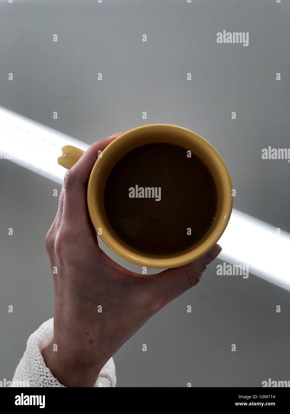Hand mit einer Tasse Tee - Smartphone-aufgenommenes Stockfoto