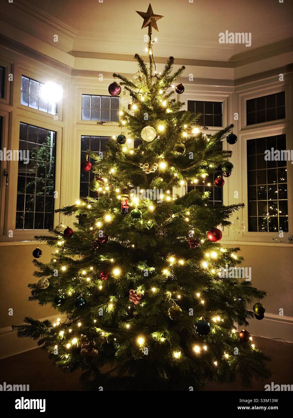 Ein Weihnachtsbaum in einem Wohnzimmer am Abend, England, Großbritannien Stockfoto