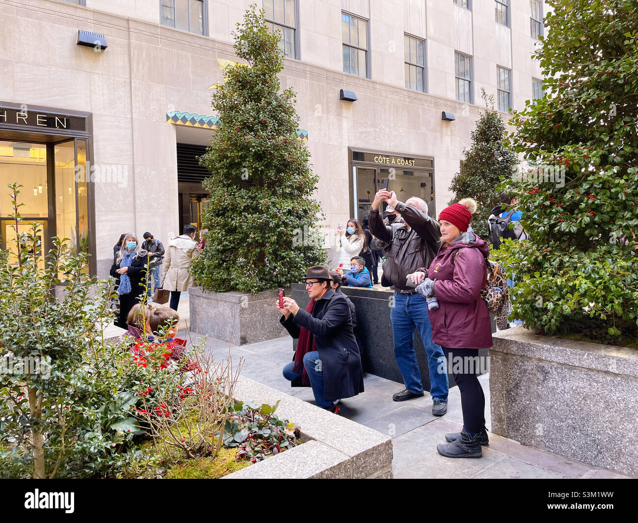 Touristen, die während eines Urlaubs in den Kanalgärten des Rockefeller Center Fotos machen, 2021, New York City, USA - Smartphone-aufgenommenes Stockfoto