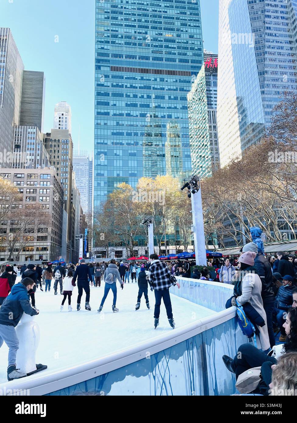 Eislaufen im Bryant Park an einem geschäftigen Wochenende im Dezember in New York City Stockfoto