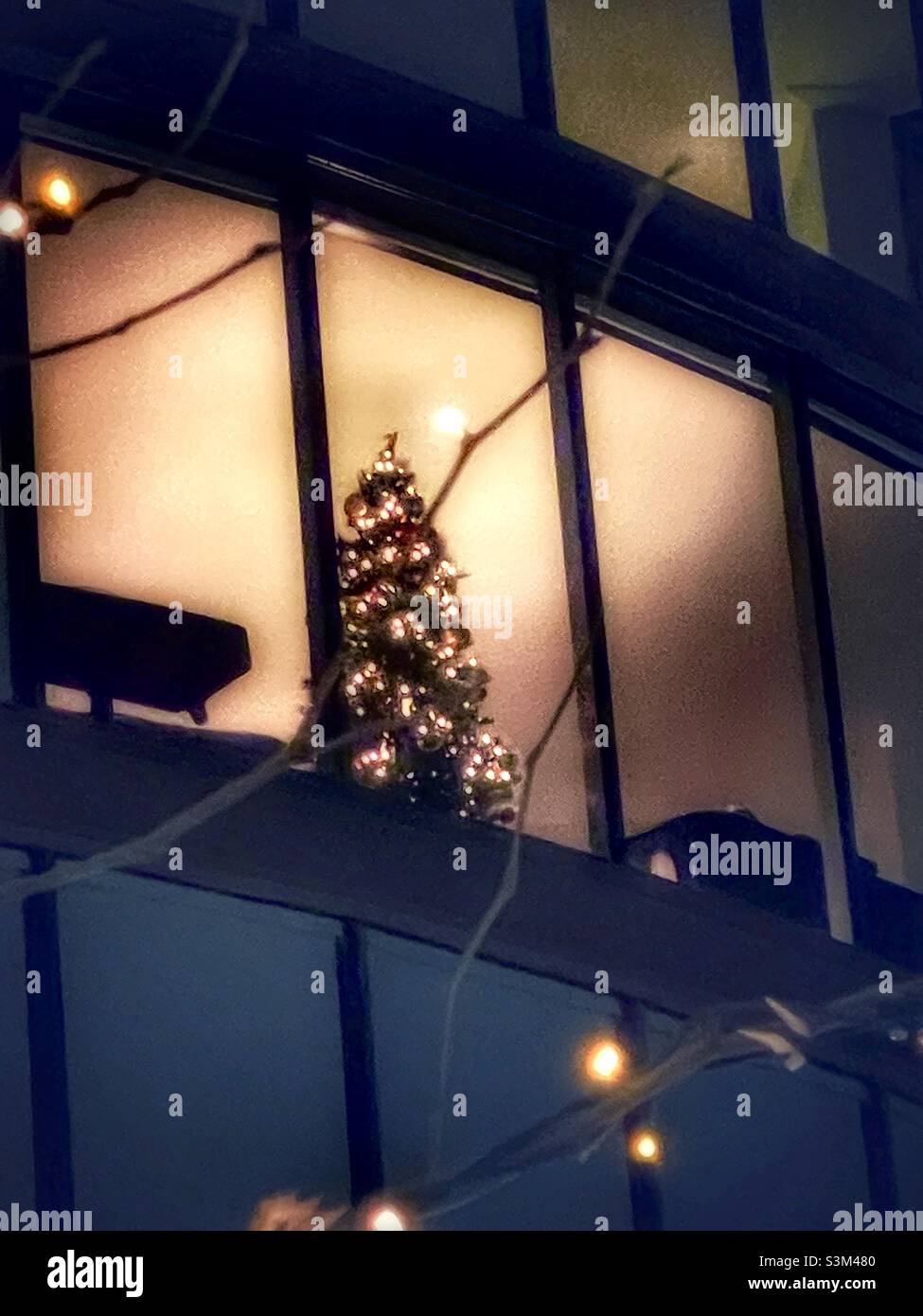 Aufnahme eines Weihnachtsbaums, der viele Stockwerke hoch in einem Wolkenkratzer in der Innenstadt von Salt Lake City, Utah, USA, leuchtet. Stockfoto