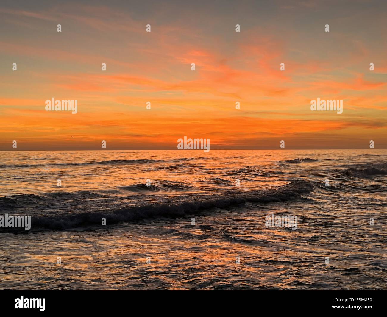Leuchtender orangefarbener Sonnenuntergang über dem Panhandle des Golfs von Mexiko in Florida Stockfoto