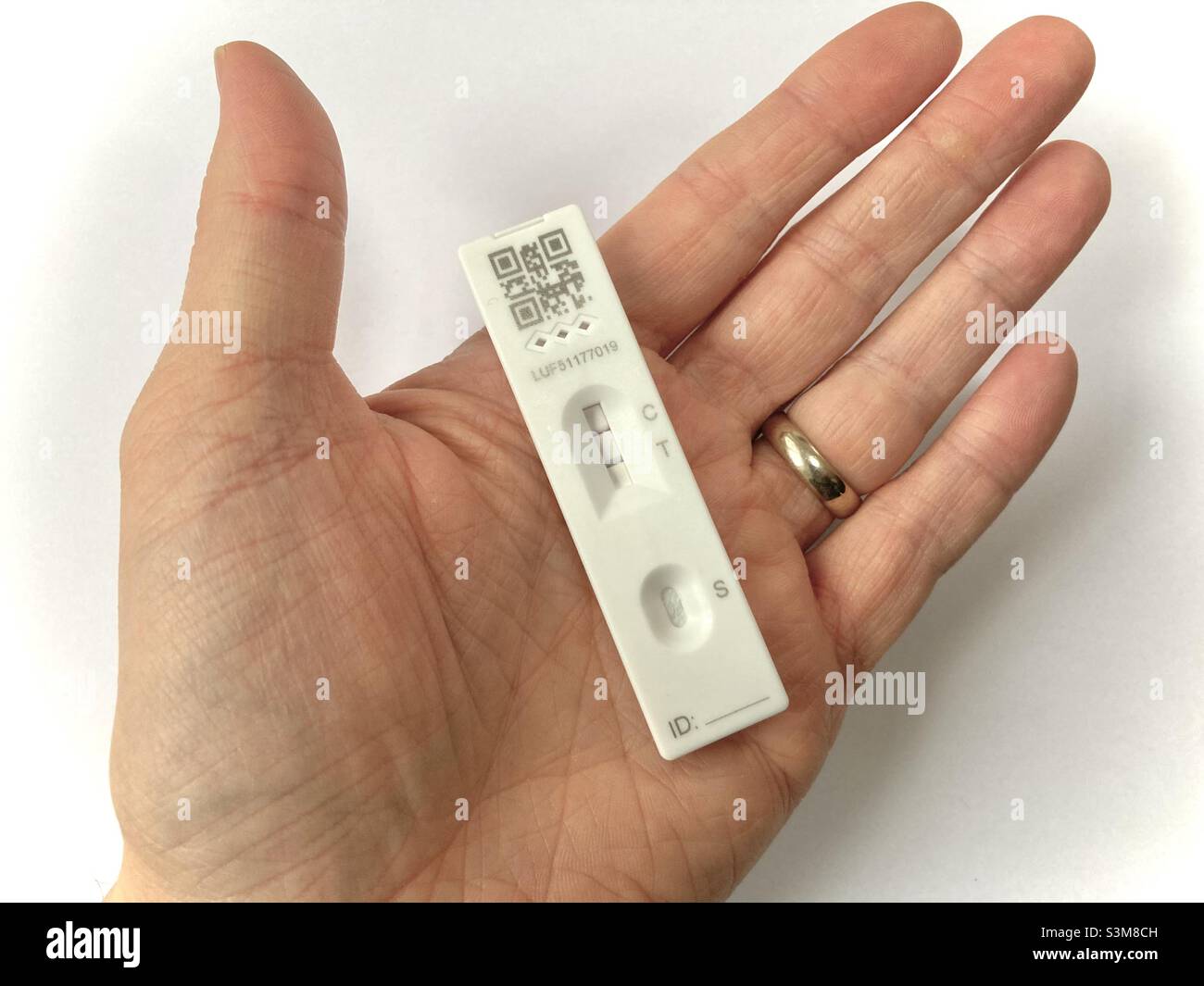 Covid 19, Omicron Hand Holding lateral flow Test positives Ergebnis - Smartphone-aufgenommenes Stockfoto