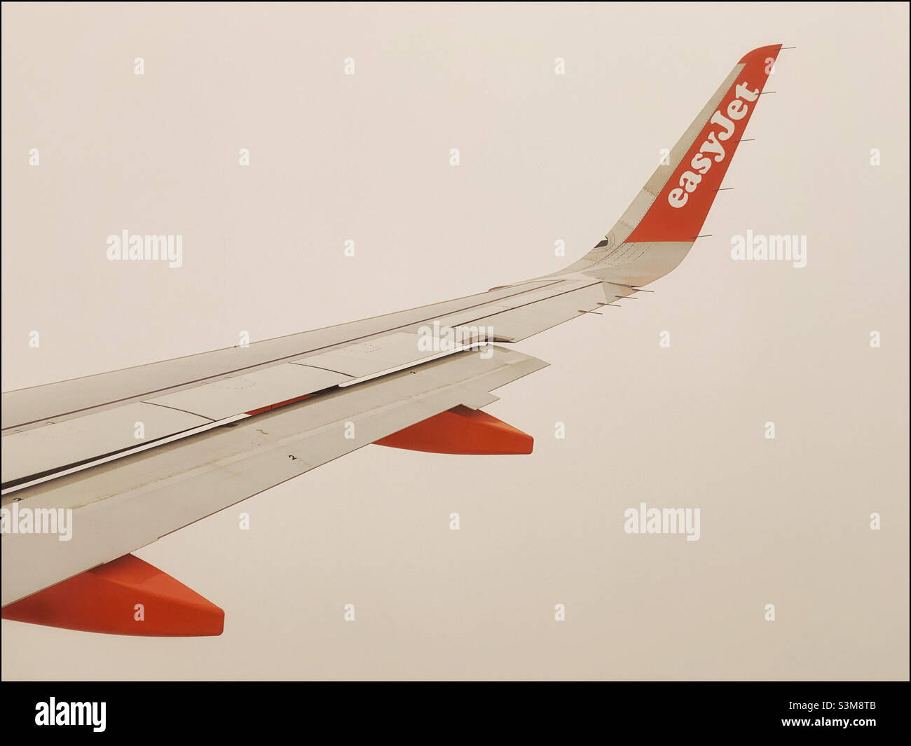 Ein Blick aus einem easyJet-Flugzeugfenster, wenn das Flugzeug in die Höhe kommt und durch die Wolken fliegt. EasyJet ist eine große europäische Billigfluggesellschaft. Foto ©️ COLIN HOSKINS. - Smartphone-aufgenommenes Stockfoto