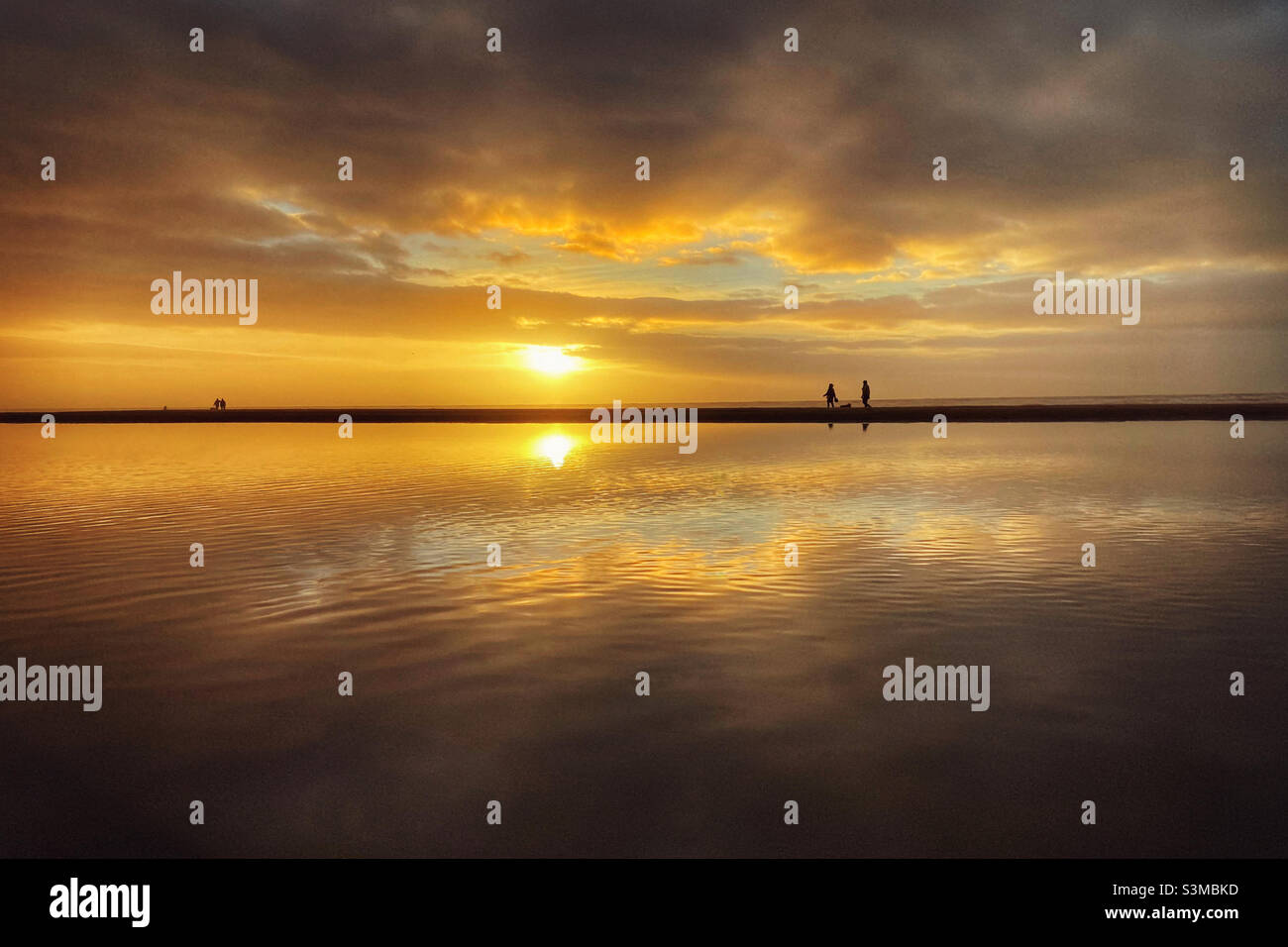 Der Sonnenuntergang im Blackpool spiegelt sich im Pool am Strand wider Stockfoto