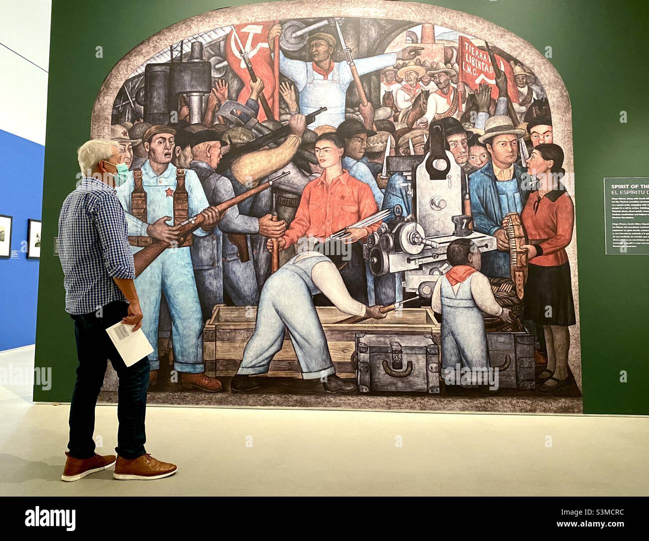 Mann, der ein Wandgemälde von Diego Rivera mit dem Titel „Spirit of the People“ im Norton Museum of Art in West Palm Beach, Florida, während der Frida Kahlo und Diego Rivera Ausstellung, 2021, ansieht. Stockfoto