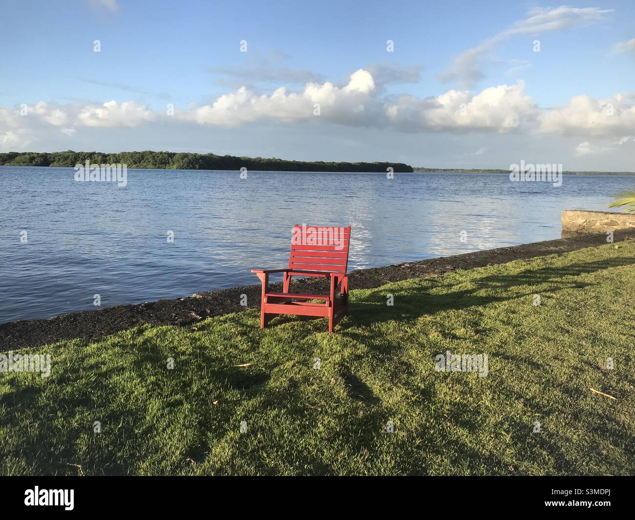 Ein roter Stuhl am Rande des Flusses Jaguaripe - Smartphone-aufgenommenes Stockfoto