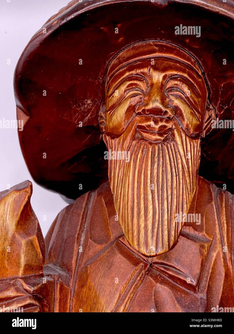 Aus Holz geschnitzte koreanische Statue eines Reisenden alten Mannes oder Mönchs mit Bart, Hut und Lächeln Stockfoto