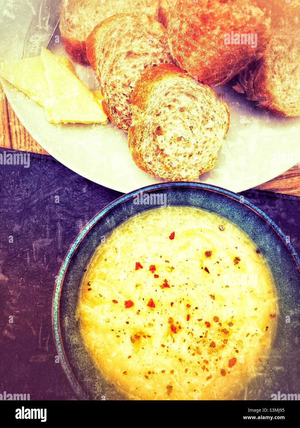 Suppe in einer Schüssel mit frisch geschnittenem knusprigem Baguette Stockfoto