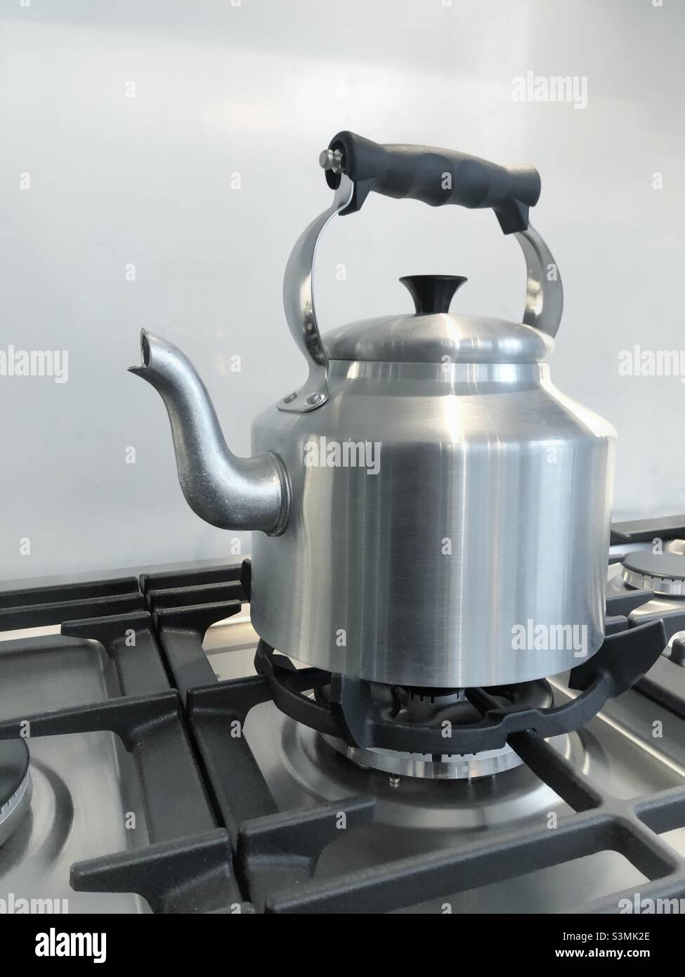 Er große silberne altmodische Wasserkocher mit Griff und Auslauf auf einem Gasherd kochendes Wasser für heiße Getränke Stockfoto
