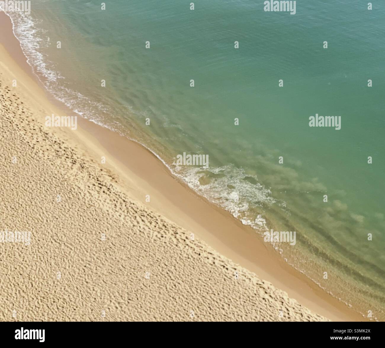 Diagonale Küste, wo Sand auf Meer am Strand trifft Stockfoto