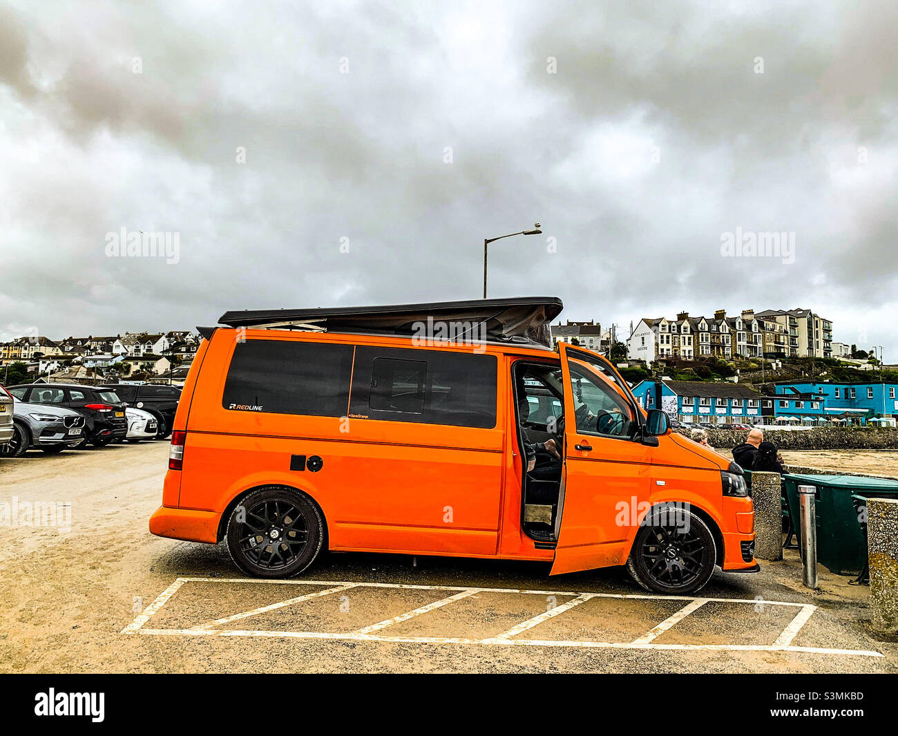 Leuchtendes orangefarbenes Wohnmobil am strand von perranporth in Cornwall Stockfoto