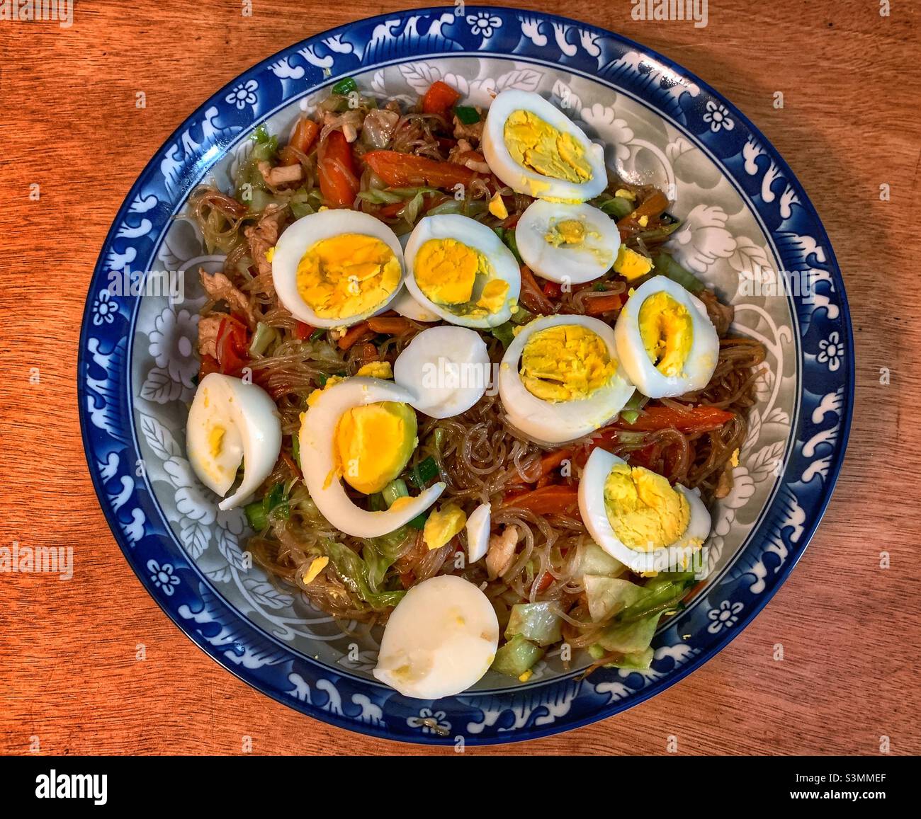 Schüssel mit sautierten Hühnergemüse Nudeln, Belag mit Scheibe gekochte Eier. Stockfoto