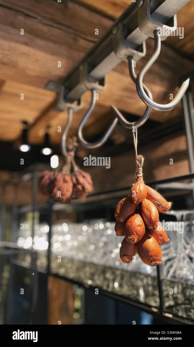 Zwiebeln hängen an einem Haken - Smartphone-aufgenommenes Stockfoto